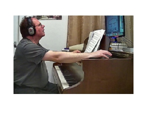 Image of pupil Dave playing his grand piano and controling a laptop in his online piano lesson